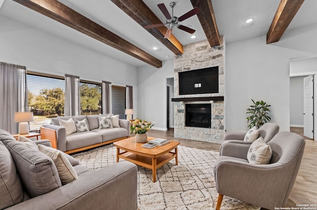 living room with beam ceiling, ceiling fan, a fireplace, and light hardwood / wood-style floors