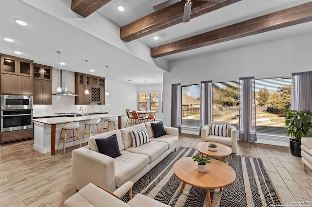 living room with beamed ceiling and light hardwood / wood-style flooring