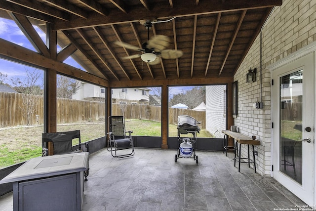 sunroom featuring vaulted ceiling with beams, wood ceiling, and ceiling fan