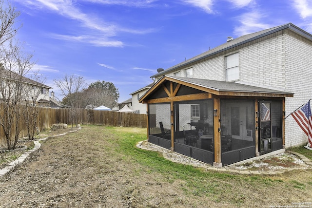 back of house featuring a lawn and a sunroom