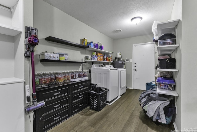 clothes washing area featuring dark hardwood / wood-style floors, washer and dryer, and a textured ceiling