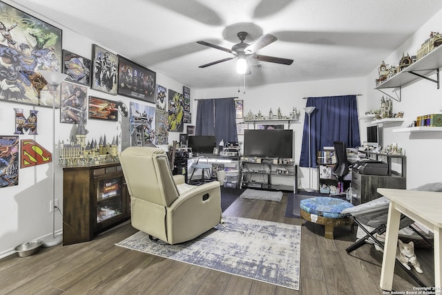 living room featuring ceiling fan, dark hardwood / wood-style floors, and a textured ceiling