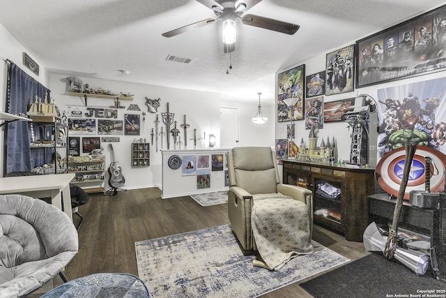 living room with hardwood / wood-style floors, a textured ceiling, and ceiling fan