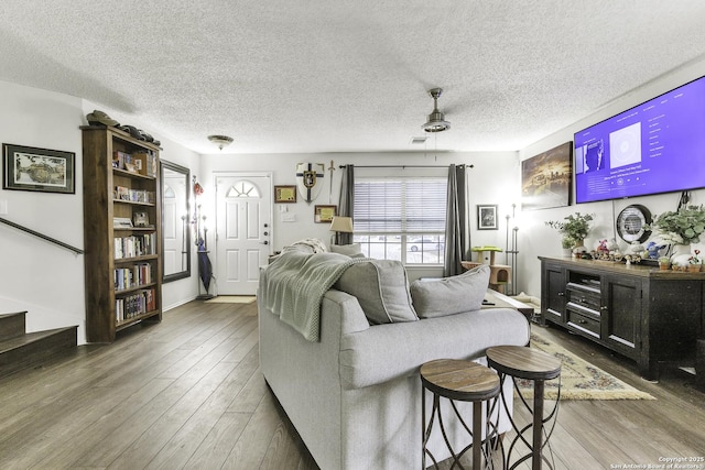 living room featuring wood-type flooring and a textured ceiling