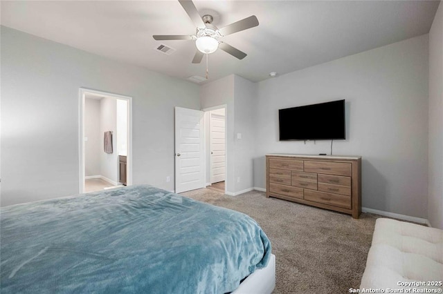 bedroom featuring ensuite bathroom, light colored carpet, and ceiling fan