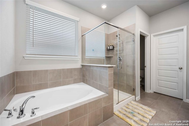 bathroom featuring tile patterned floors, toilet, and separate shower and tub