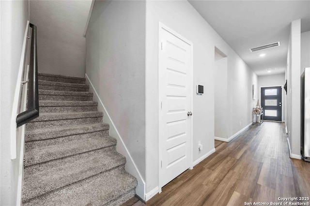 stairway with hardwood / wood-style floors