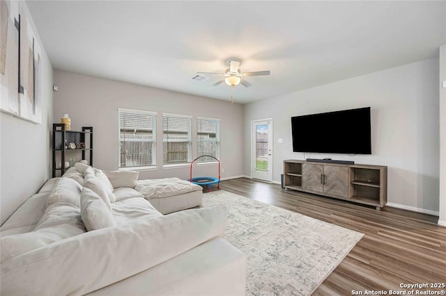 living room featuring ceiling fan and dark hardwood / wood-style flooring