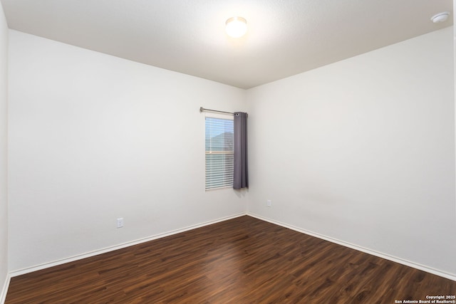 unfurnished room with dark hardwood / wood-style flooring