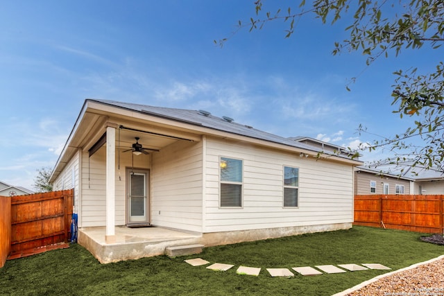 back of property with a yard, a patio, and ceiling fan