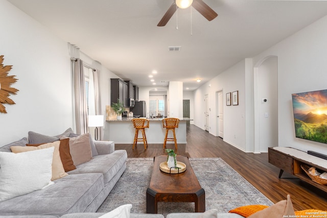 living room featuring dark hardwood / wood-style floors and ceiling fan