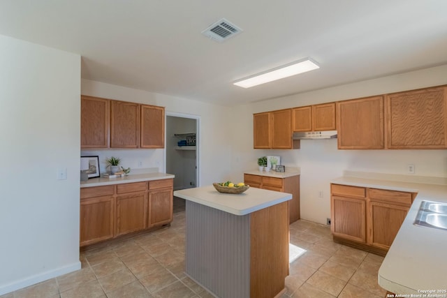 kitchen featuring sink, light tile patterned flooring, and a kitchen island