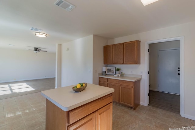 kitchen featuring light tile patterned floors, a center island, and ceiling fan