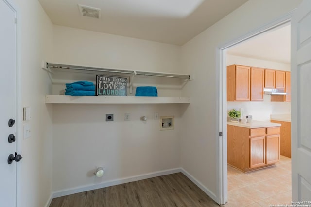 laundry room with gas dryer hookup, hookup for an electric dryer, hookup for a washing machine, and light wood-type flooring