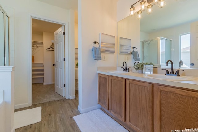 bathroom with vanity, a shower with shower door, and hardwood / wood-style floors