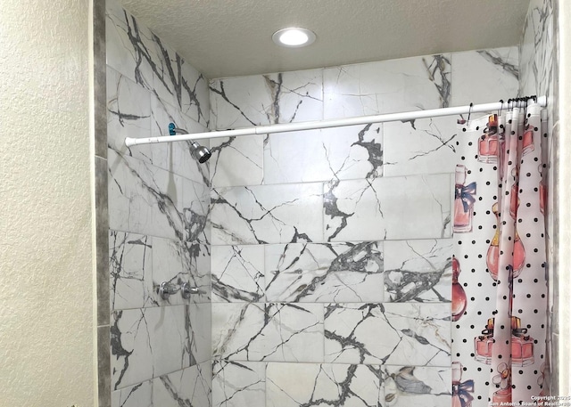 bathroom featuring curtained shower and a textured ceiling