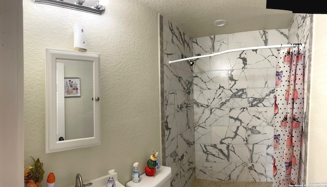 bathroom featuring toilet, a textured ceiling, and a shower with curtain