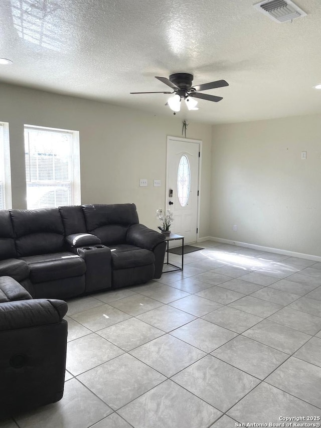 tiled living room featuring a textured ceiling and ceiling fan