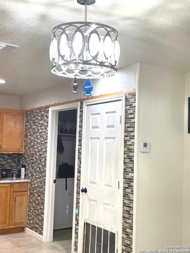 foyer entrance featuring light tile patterned floors and a textured ceiling