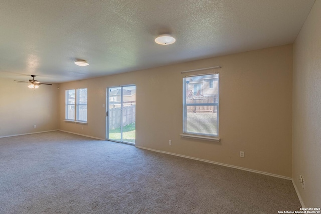 carpeted empty room featuring ceiling fan and a textured ceiling