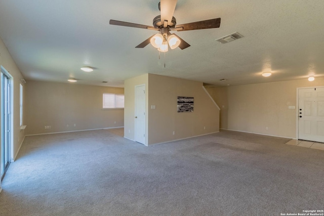 unfurnished living room with ceiling fan, light carpet, and a textured ceiling