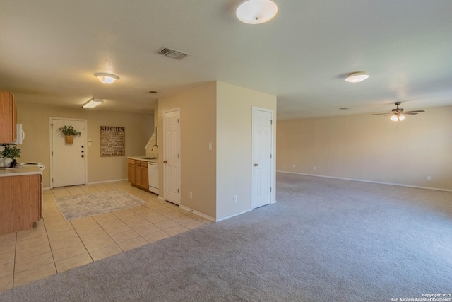 kitchen with dishwasher, sink, light colored carpet, and ceiling fan