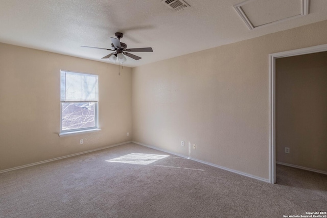 carpeted spare room featuring ceiling fan and a textured ceiling