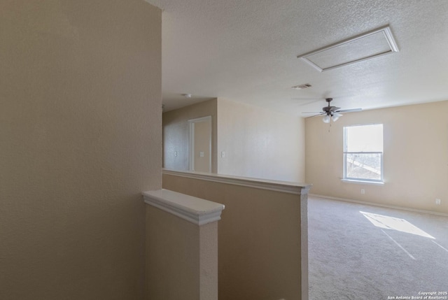 spare room with light carpet and a textured ceiling