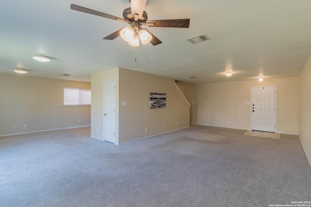 carpeted empty room featuring ceiling fan and a textured ceiling