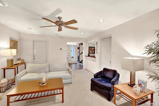 living room featuring light colored carpet and ceiling fan