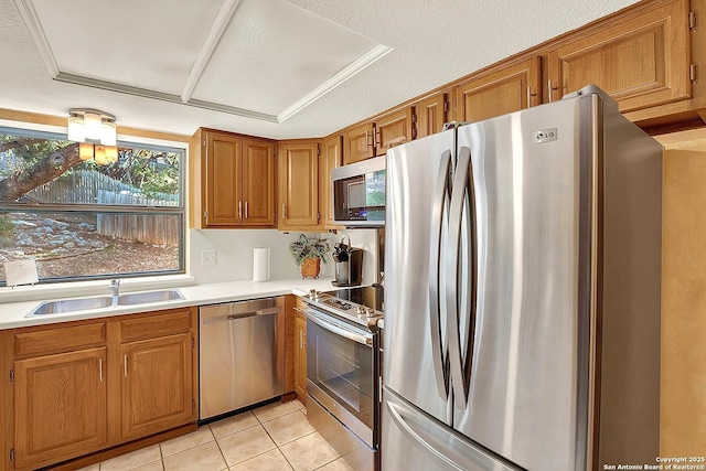 kitchen featuring appliances with stainless steel finishes, sink, light tile patterned floors, and a textured ceiling