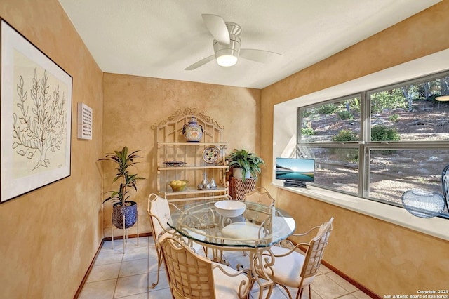 tiled dining space featuring ceiling fan