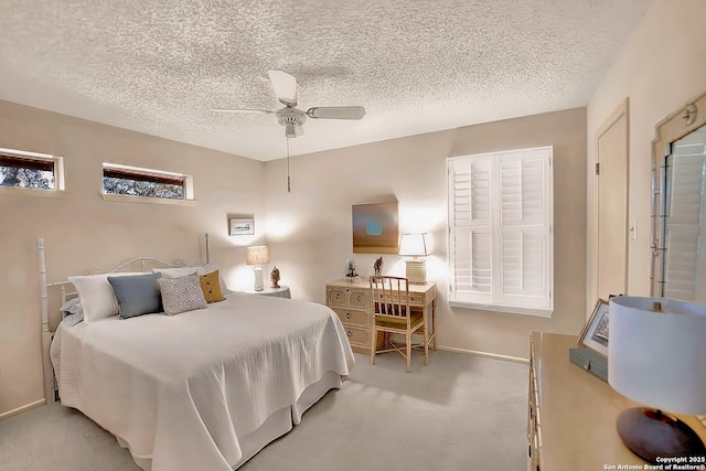 bedroom with ceiling fan, light colored carpet, and a textured ceiling