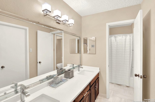 bathroom featuring vanity, a textured ceiling, and toilet