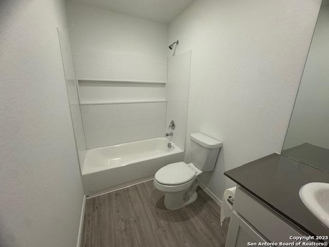 full bathroom featuring vanity, wood-type flooring, tub / shower combination, and toilet