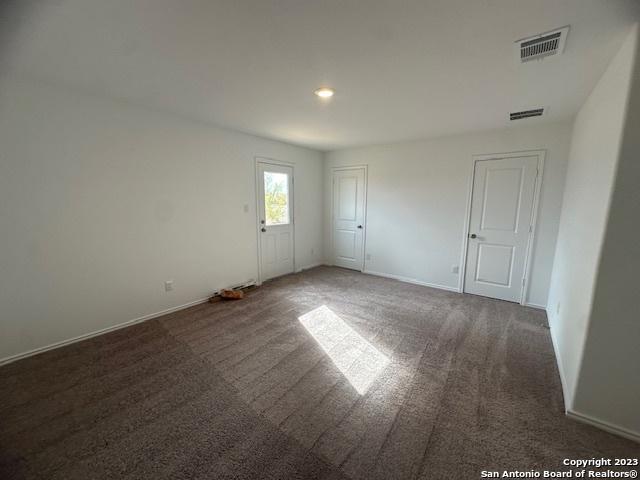 spare room with dark colored carpet