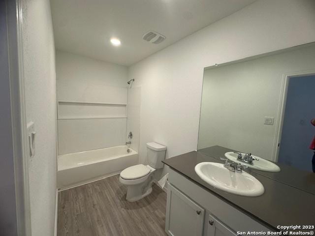 full bathroom with vanity, bathtub / shower combination, hardwood / wood-style floors, and toilet