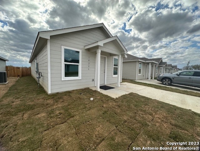 bungalow with central AC unit and a front lawn