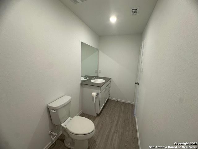 bathroom featuring hardwood / wood-style flooring, vanity, and toilet