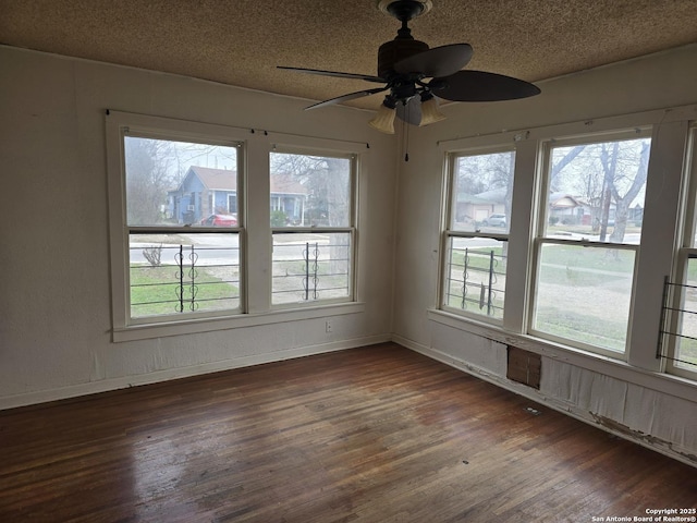 spare room featuring ceiling fan, dark hardwood / wood-style floors, and a textured ceiling