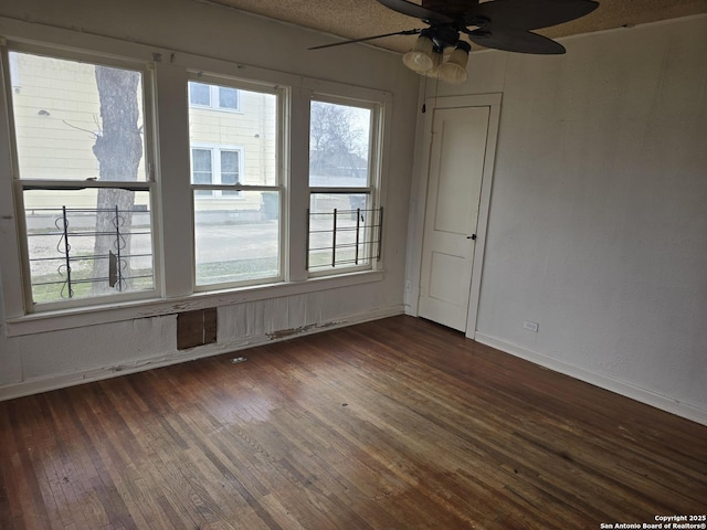 spare room featuring ceiling fan and dark hardwood / wood-style flooring