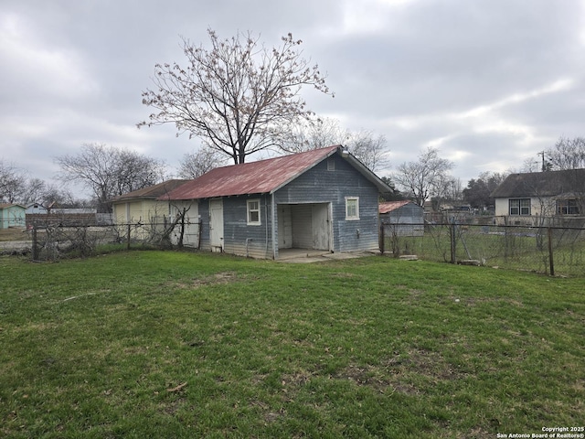 back of house featuring an outdoor structure and a lawn