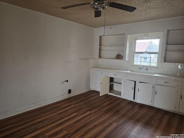 kitchen featuring sink, dark hardwood / wood-style floors, tasteful backsplash, a textured ceiling, and white cabinets