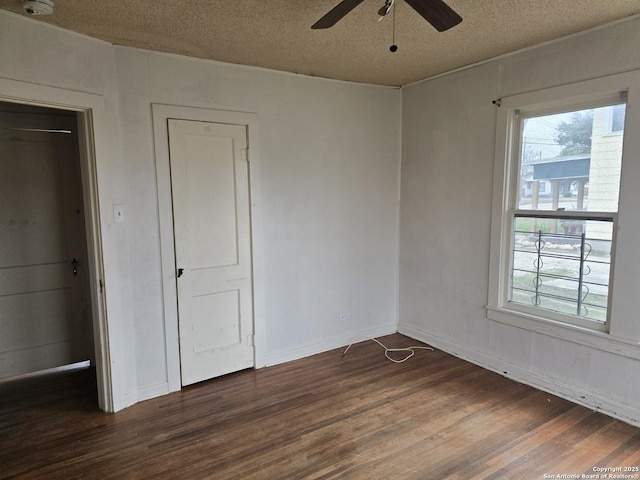 unfurnished bedroom with ceiling fan, dark wood-type flooring, and a textured ceiling