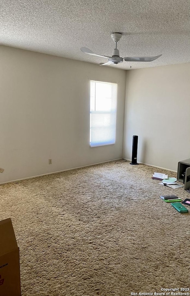 carpeted spare room with a textured ceiling and ceiling fan