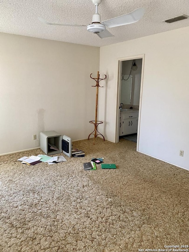 spare room featuring ceiling fan, carpet flooring, sink, and a textured ceiling