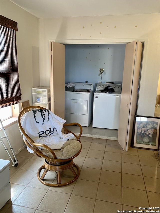 clothes washing area featuring light tile patterned flooring and washer and dryer