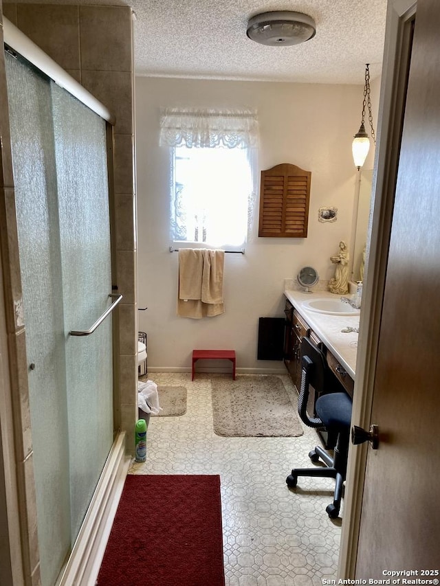 bathroom with walk in shower, vanity, and a textured ceiling