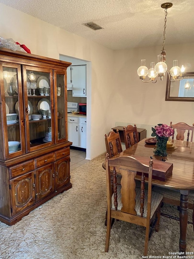 carpeted dining area with a textured ceiling