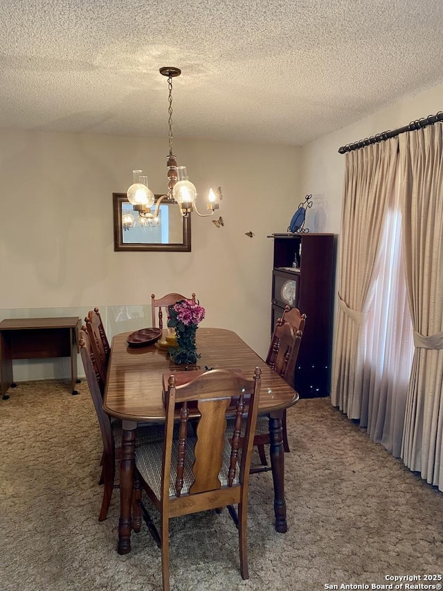 dining space with an inviting chandelier, a textured ceiling, and carpet